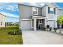 Townhome with gray exterior, two-car garage, and front landscaping at 16701 Maude Dr, Wimauma, FL 33598