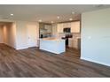 Open-concept kitchen with island, stainless steel appliances, white cabinetry, and a modern design at 10269 Kalamazoo Pl, Parrish, FL 34219