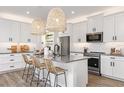 Modern kitchen with white cabinets, gray countertops, and a large island at 4357 Cloud Hopper Way, Lutz, FL 33559