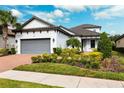 House exterior with gray garage door and well-maintained landscaping at 8520 Grand Alberato Rd, Tampa, FL 33647