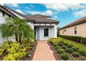 Brick walkway leading to the house entrance, surrounded by greenery at 8520 Grand Alberato Rd, Tampa, FL 33647
