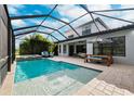 Inviting pool and spa with covered patio and outdoor seating at 8520 Grand Alberato Rd, Tampa, FL 33647