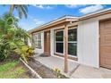 Front view of the house featuring a brown door and windows at 1005 Greenleaf Way, Tarpon Springs, FL 34689