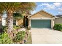 House exterior featuring a tan facade, green garage door, and landscaping at 12320 Ballentrae Forest Dr, Riverview, FL 33579