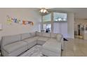 Open living room featuring a large sectional sofa, vaulted ceilings, and bright natural light at 311 Sugar Creek Dr, Plant City, FL 33563