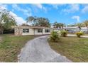 Front view of a ranch home with a long driveway at 615 16Th Nw St, Largo, FL 33770