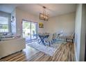 Dining room with hardwood floors, modern chandelier, and access to backyard patio at 20028 Satin Leaf Ave, Tampa, FL 33647