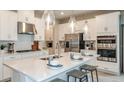 Modern kitchen with white cabinets, stainless steel appliances, and large island at 5107 Slate Hue Pl, Apollo Beach, FL 33572