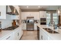 Modern kitchen with white cabinets, stainless steel appliances, and an island at 5107 Slate Hue Pl, Apollo Beach, FL 33572