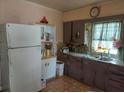 A galley kitchen with wood cabinets, double sink, and refrigerator at 5748 Montana Ave, New Port Richey, FL 34652