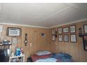 Cozy bedroom with wood paneling and framed artwork at 5748 Montana Ave, New Port Richey, FL 34652