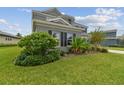 Two-story house with gray siding, landscaping, and a neatly manicured lawn at 6317 Brevada Ln, Apollo Beach, FL 33572
