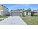 Gray house with a two-car garage and landscaped lawn at 7231 Somerset Pond Dr, Ruskin, FL 33573