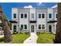 A modern townhome featuring a well-manicured lawn and stylish black awning over the front door at 3402 E 28Th Ave # 1, Tampa, FL 33605