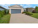 Attractive single-story home with a gray garage door and lush landscaping at 5907 Silver Sun Dr, Apollo Beach, FL 33572