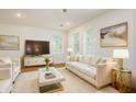 Bright and airy living room with white leather sofa and large flat-screen TV at 880 17Th S Ave, St Petersburg, FL 33701