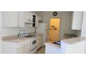 White kitchen with appliances and a small pantry at 10024 Heathcliff St, Spring Hill, FL 34608