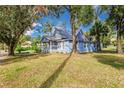 Side view of a charming light blue house nestled amongst mature trees at 106 E Calhoun St, Plant City, FL 33563