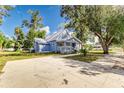 Light blue house with a metal roof, large yard, and a spacious concrete driveway at 106 E Calhoun St, Plant City, FL 33563