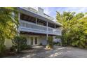Charming two-story home featuring a spacious balcony and lush greenery at 3302 E Maritana Dr, St Pete Beach, FL 33706