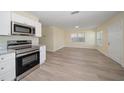 Open living room and kitchen with wood-look flooring at 3305 W Kathleen St, Tampa, FL 33607