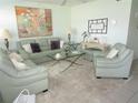 Living room with light green leather sofas, coffee table, and large artwork at 6000 20Th N St # 129, St Petersburg, FL 33714