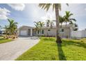 Modern, single-story home with a paved driveway and landscaping at 7872 1St S Ave, St Petersburg, FL 33707