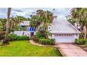 White two-story house with a white garage and lush landscaping at 807 2Nd S Ave, Tierra Verde, FL 33715