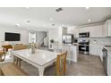 Open-concept living room and kitchen with a dining table and modern appliances, creating a bright and inviting space at 10316 Cross River Trl, Parrish, FL 34219