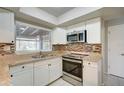 Modern kitchen with white cabinets, granite counters, and stainless steel appliances at 18138 Lake Worth Blvd, Port Charlotte, FL 33948