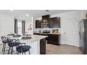 Modern kitchen with dark cabinets, a large island, and stainless steel appliances at 5270 Salt Marsh Rd, Wimauma, FL 33598