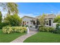 Well-maintained gray house featuring a lush lawn, walkway and manicured landscaping at 860 25Th N Ave, St Petersburg, FL 33704