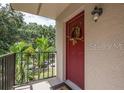 Inviting condo entry with red door and wreath, overlooking green landscape at 11701 Raintree Village Blvd # C, Temple Terrace, FL 33617