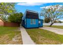 Modern blue home with unique architectural design, surrounded by greenery and a well-kept lawn at 225 35Th N St, St Petersburg, FL 33713