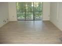 Living room with light gray vinyl plank flooring and sliding glass doors at 3161 Lake Pine S Way # B1, Tarpon Springs, FL 34688