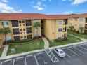 Condo building exterior with parking and landscaping at 4305 Bayside Village Dr # 104, Tampa, FL 33615