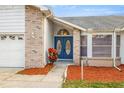 Inviting front entrance with double blue doors and brick accents at 8404 Millwood Dr, Hudson, FL 34667