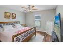 Cozy bedroom with wood floors, a ceiling fan, and natural light, offering a serene retreat at 9407 Channing Hill Dr, Ruskin, FL 33573
