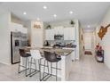 Bright kitchen with granite countertops, stainless steel appliances, and a large island with bar seating at 9407 Channing Hill Dr, Ruskin, FL 33573