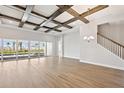 Spacious living room with coffered ceilings, wood floors, and sliding glass doors to the pool at 17525 Glistening Ct, Venice, FL 34293