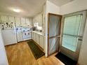 Galley kitchen with white cabinets and laminate flooring at 34539 Violet N Dr, Pinellas Park, FL 33781