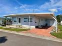 Single-wide manufactured home with carport and landscaping at 34539 Violet N Dr, Pinellas Park, FL 33781