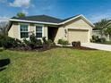 Tan house with two-car garage and landscaped yard at 8519 Sunshower Pl, Parrish, FL 34219