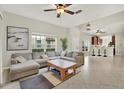 Spacious living room featuring a large sectional sofa and a view into the kitchen at 20208 Water Hickory Pl, Tampa, FL 33647