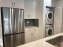 Stainless steel refrigerator and stackable washer and dryer in kitchen at 29254 Bay Hollow Dr # 3262, Wesley Chapel, FL 33543
