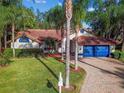 Single-story home with a large yard and palm trees at 5479 Blue Heron Ln, Wesley Chapel, FL 33543