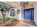 Inviting front entrance with a stylish blue door and landscaped walkway at 5479 Blue Heron Ln, Wesley Chapel, FL 33543