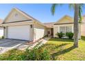 Front view of a single-story house with a two-car garage and lush landscaping at 9708 Little Pond Way, Tampa, FL 33647