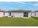 Private backyard with grass lawn and sliding glass door access at 29596 Fedora Cir, Brooksville, FL 34602