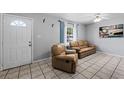 Bright living room featuring tiled floors and comfy leather reclining furniture at 3334 W Heiter St, Tampa, FL 33607